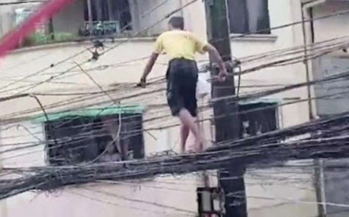 (VIDEO) Hombre camina sobre cables de luz para ganar comida para su familia