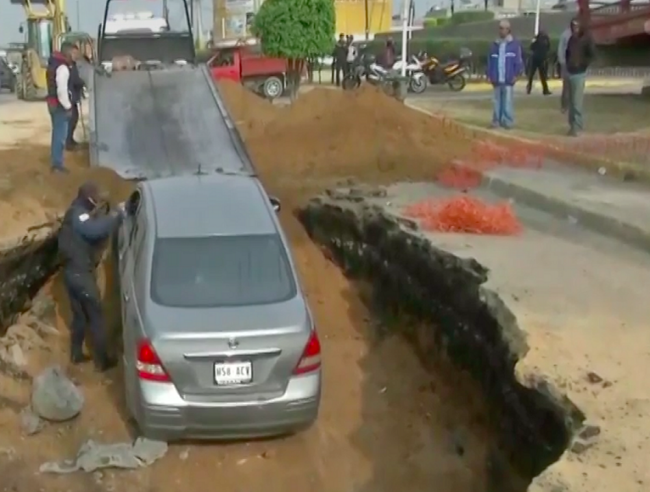 Auto cae en socavón en avenida de Edomex