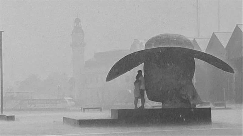 Retratan a pareja que se protegía de la lluvia bajo escultura en España