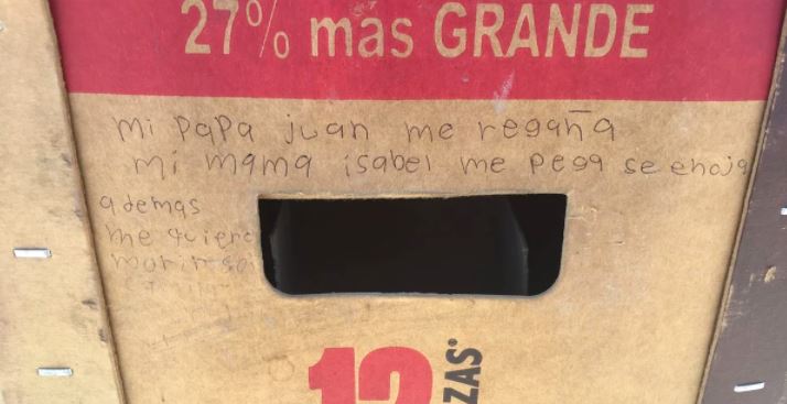 Niña maltratada pide ayuda escribiendo en un cartón de cervezas